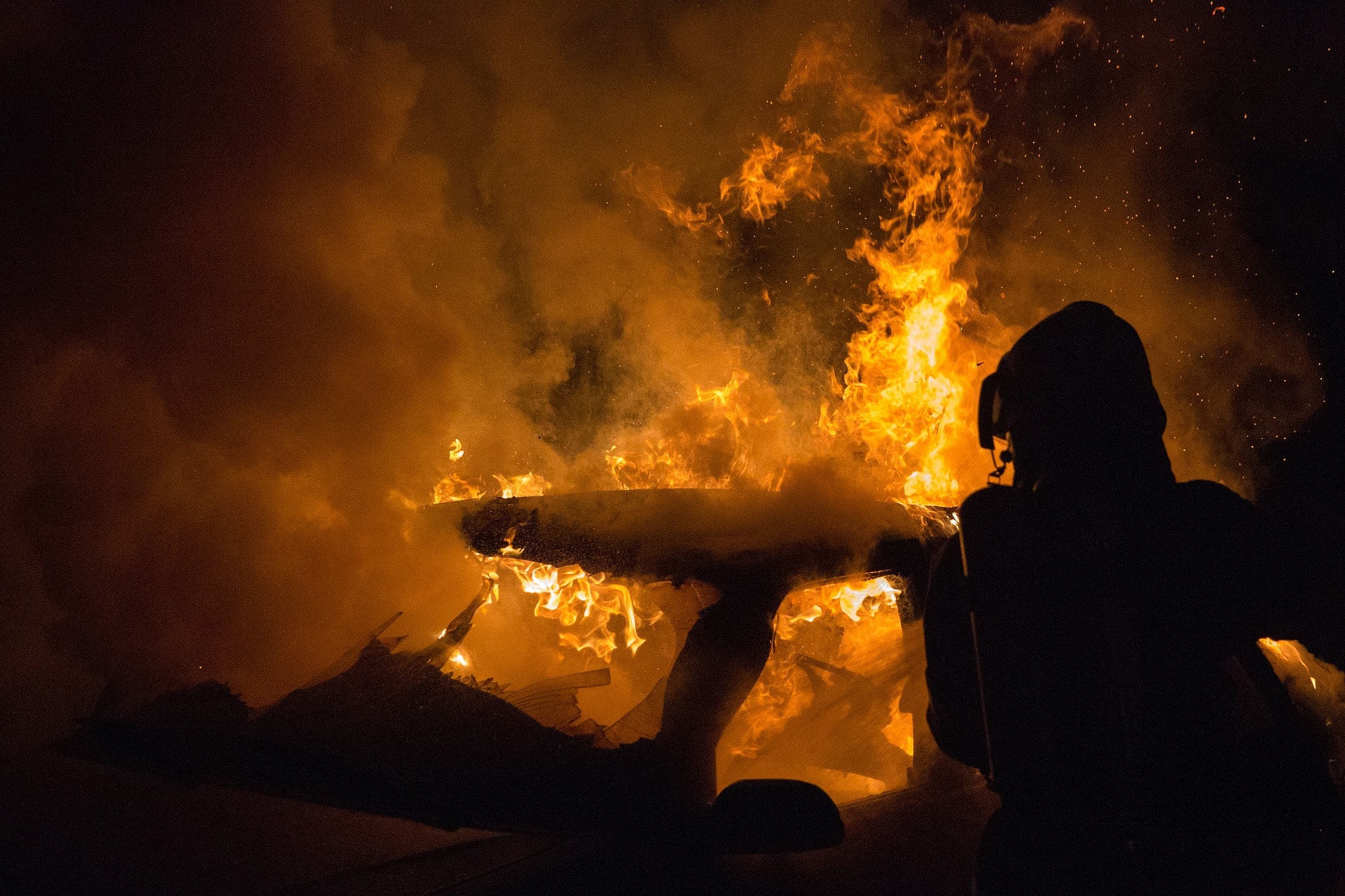 Firefighter silhouette near a controlled fire scene